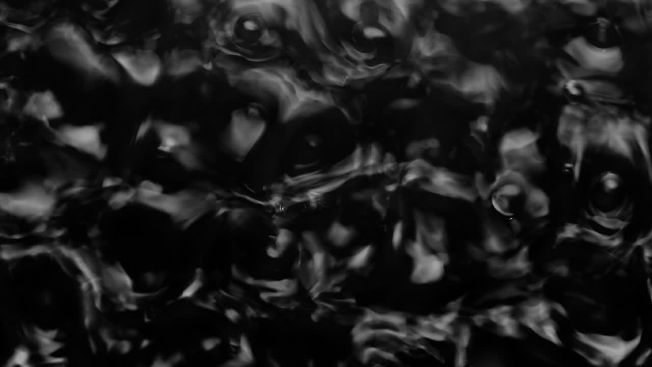 salpicaduras y gotas en la superficie del líquido. abstracto fondo negro vibración del agua