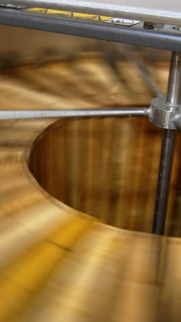quick rotation of wooden honey frames in the centrifuge machine. electric equipment for honey harvesting at apiary. vertical video