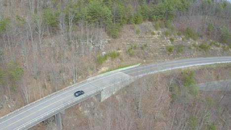 aerial view of a car driving on a winding mountain road