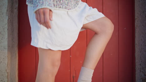 legs wearing casual loafers on street closeup. casual slim girl posing old house