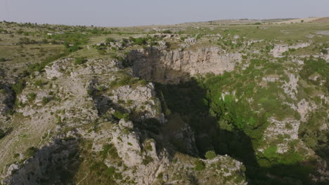 Aerial-flyover-of-the-canyon-and-caves-opposite-the-town-of-Matera-in-Italy