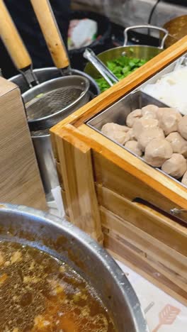 boiling soup and ingredients at a street market