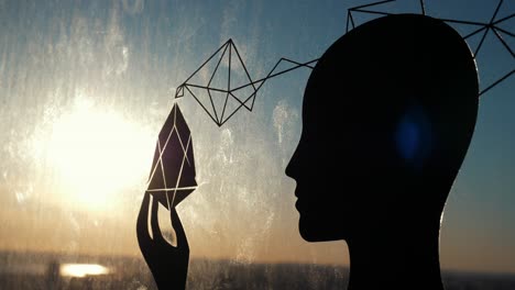 silhouette of a person with geometric design, watching sunset through a window