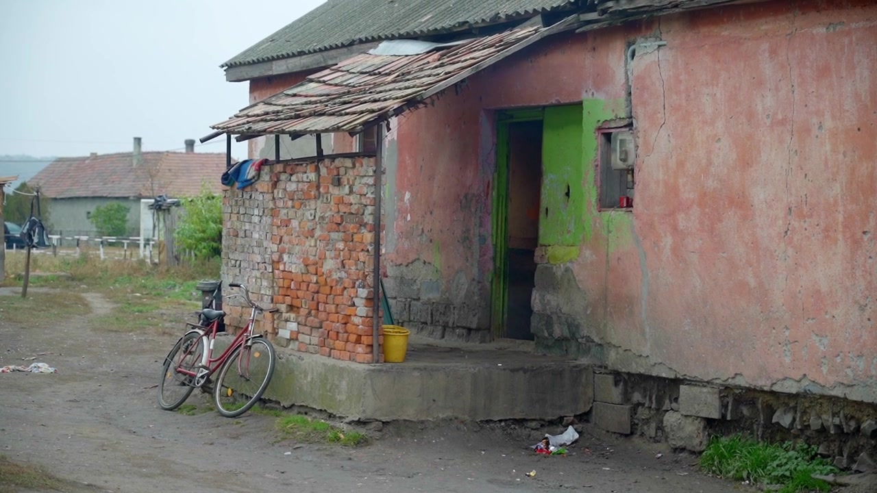 bicycle leaning against an unplastered brick wall in the yard of a house in a poor slum