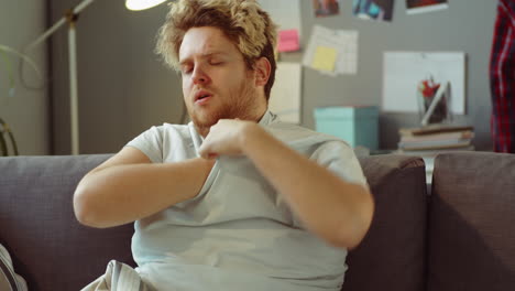 hombre enfermo midiendo la temperatura en casa