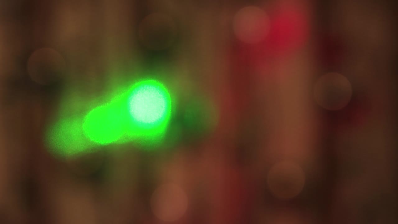 luces blancas suaves y festivas en la oscuridad y rayos verdes y rojos que se mueven rápidamente.