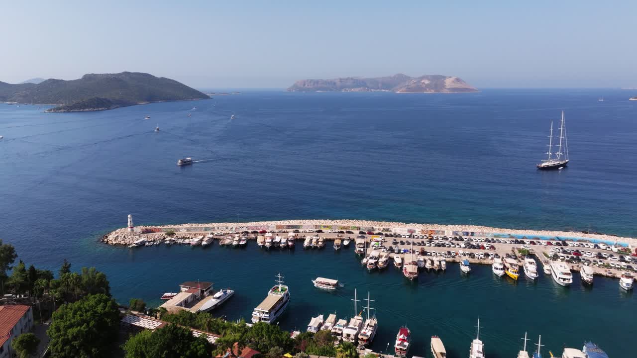 Aerial dolly of Kas, Antalya, showing the coastal town with blue waters, boats, and surrounding hills in Turkey