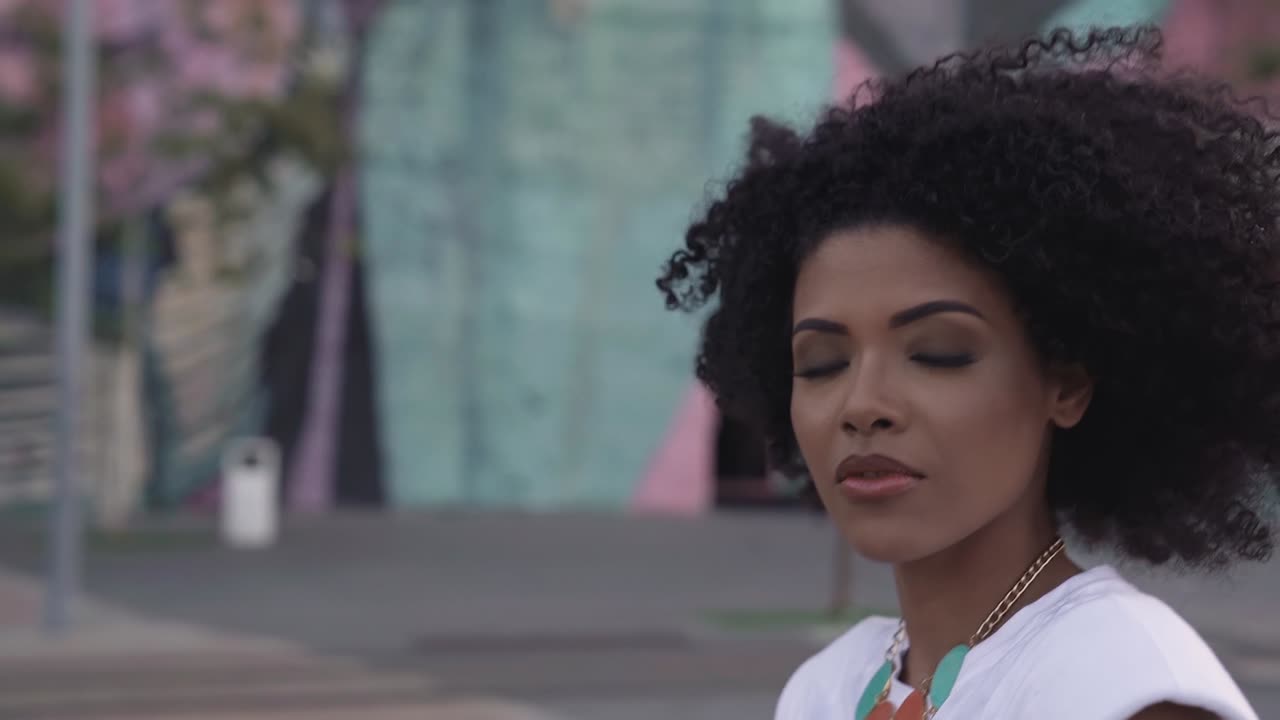 Donna afro-brasiliana sicura di sé che cammina e incrocia lo sguardo, primo piano