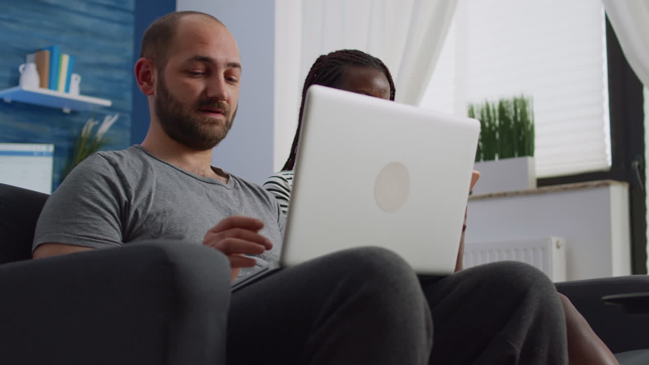 Young interracial couple using devices with technology