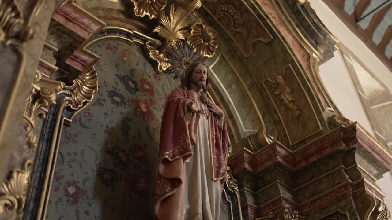 Sacred statue of Jesus in detailed robes within an ornate church alcove