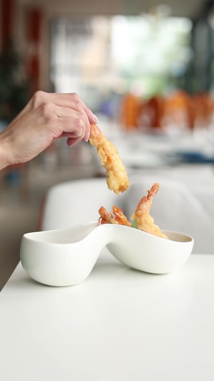mujer comiendo camarón tempura