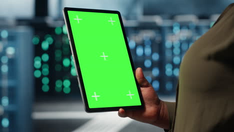 software developer at work using green screen tablet in data center
