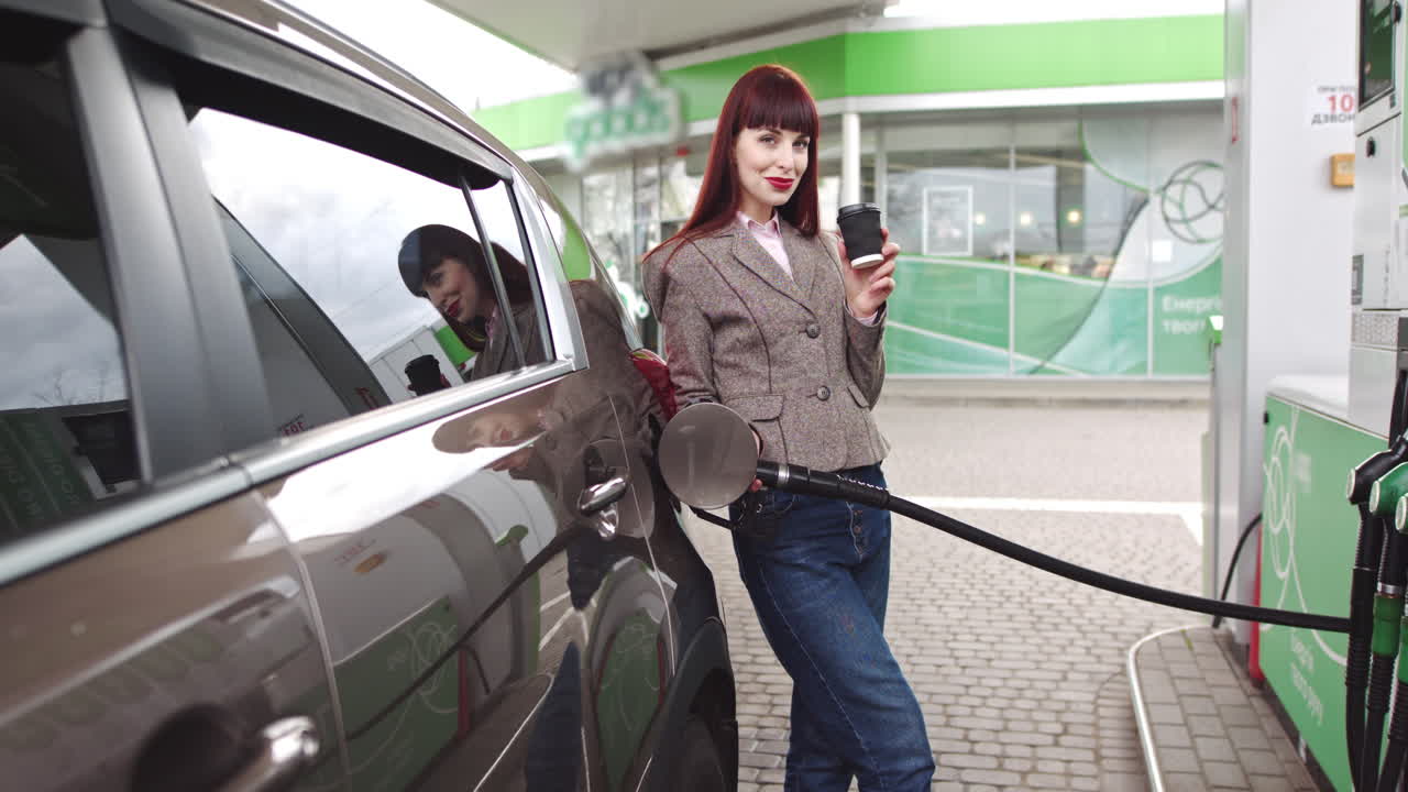 Woman filling up a car at a gas station with coffee