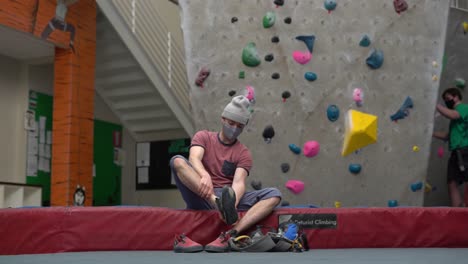 rock climber climbing an indoor rock wall using athletic chalk for grip-8