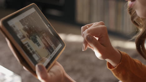 primer plano de una mujer usando una tableta digital en casa mirando a través de fotografías de vacaciones
