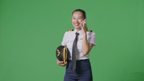 una piloto sonriente hablando por teléfono.