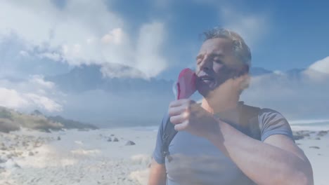 caucasian senior man wearing face mask hiking by the coast over fast moving clouds