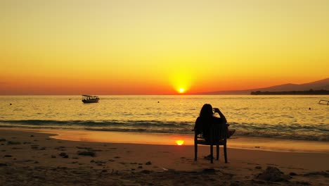 woman relaxing on the beach during the golden sunset