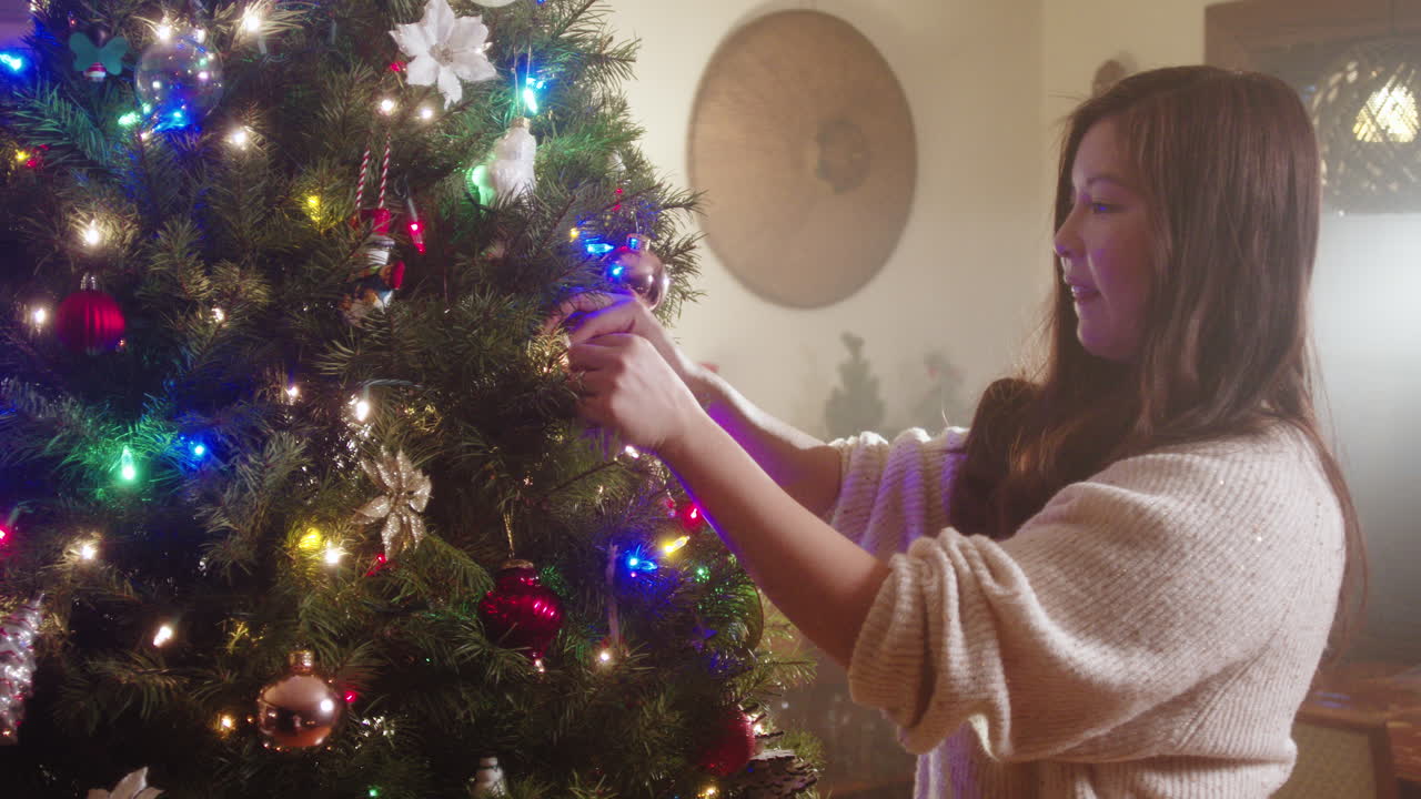 Mujer decorando un árbol de navidad