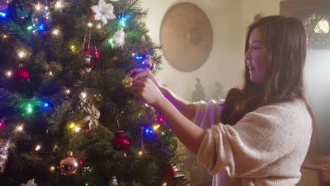 mujer decorando un árbol de navidad
