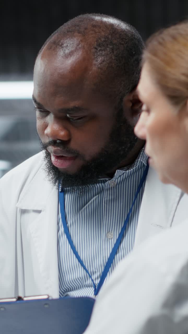 Vertical Video Two researchers testing patient during drug trial and recording side effects