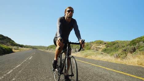 hombre triatleta en bicicleta en el camino del campo