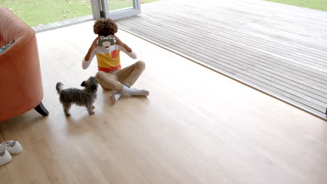 african american boy using vr headset, with his pet dog, copy space, slow motion