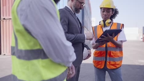 professional female engineer explaining cargo loading process to investor or manager on tablet. collaborated of partners diversity in logistics business working together, agree project, investment or employment.