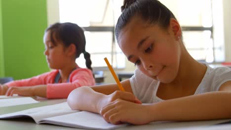 schoolgirl studying at desk in classroom at school 4k