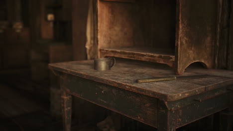 close-up of a rustic wooden table with a cup and knife