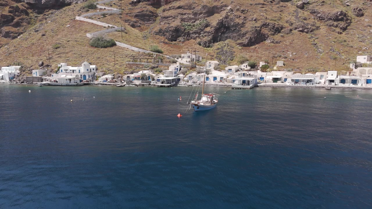 Suggestivo villaggio costiero di Korfos sull'isola di Thirasia con barche che galleggiano sul Mar Egeo