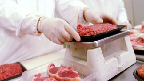 butcher checking the weight of meat