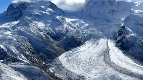 Incredible-stunning-morning-Gornergrat-Zermatt-Glacier-ice-crevasse-river-Swiss-Alps-top-The-Matterhorn-summit-ski-resort-landscape-scenery-aerial-drone-autumn-Railway-Switzerland-pan-up