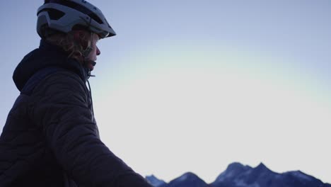 a cyclist catches his breath on a ridge at sunrise