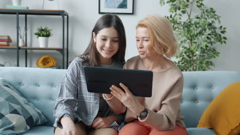 grandmother and granddaughter enjoying time together on tablet