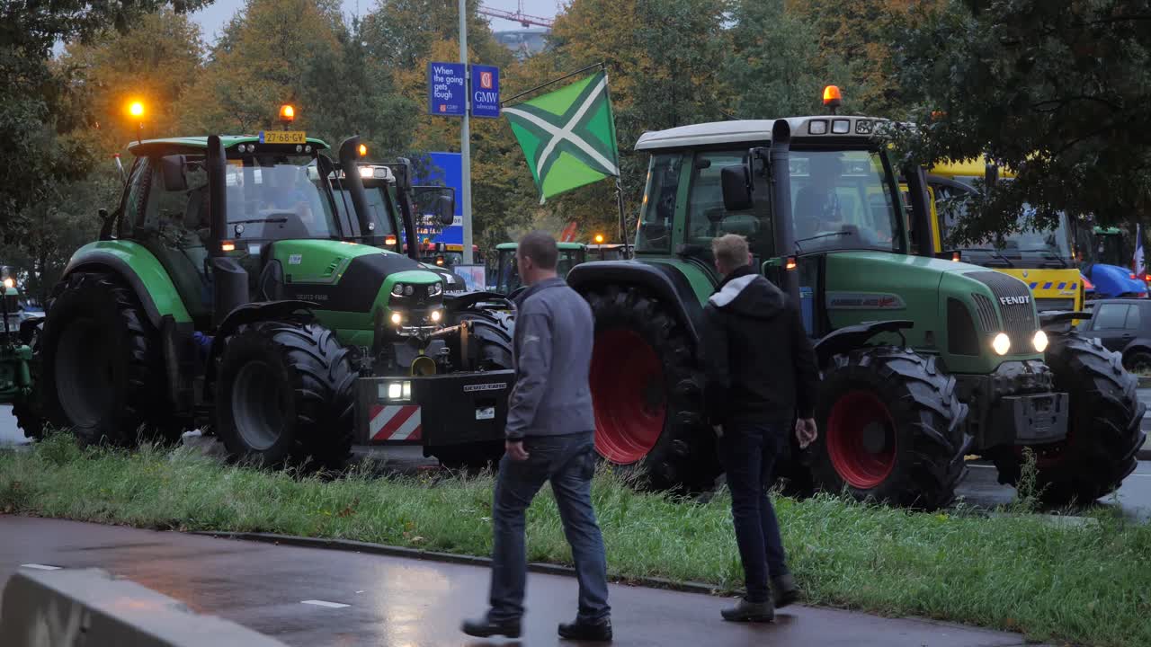 Tractors on the public road in The Hague during the farmers protests against emission regulations. Biggest traffic jam caused by farmers in The Netherlands. Slow motion in sixty frames per second.
