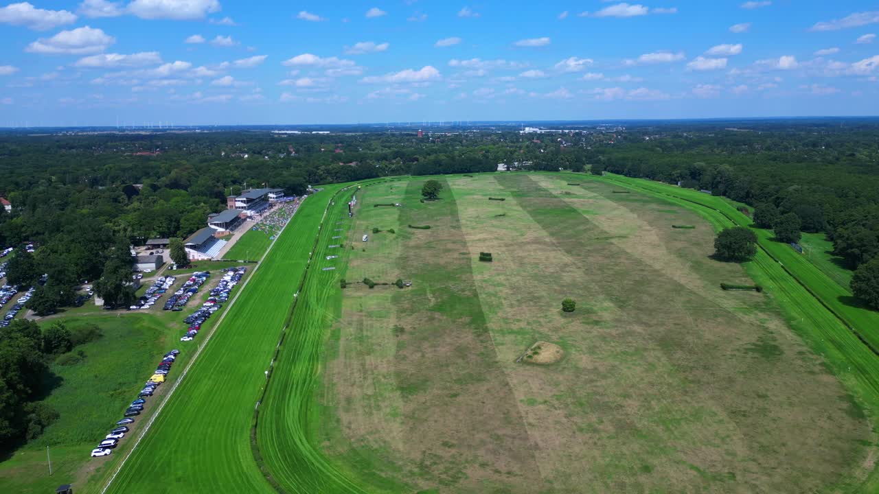 horse racing track with spectators enjoying the competition on a sunny summer day. Perfect aerial view flight fly push forward drone