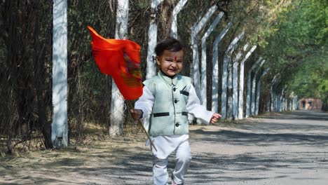 niño caminando bandera sagrada de azafrán con el dios rama ídolo en el día desde un ángulo plano