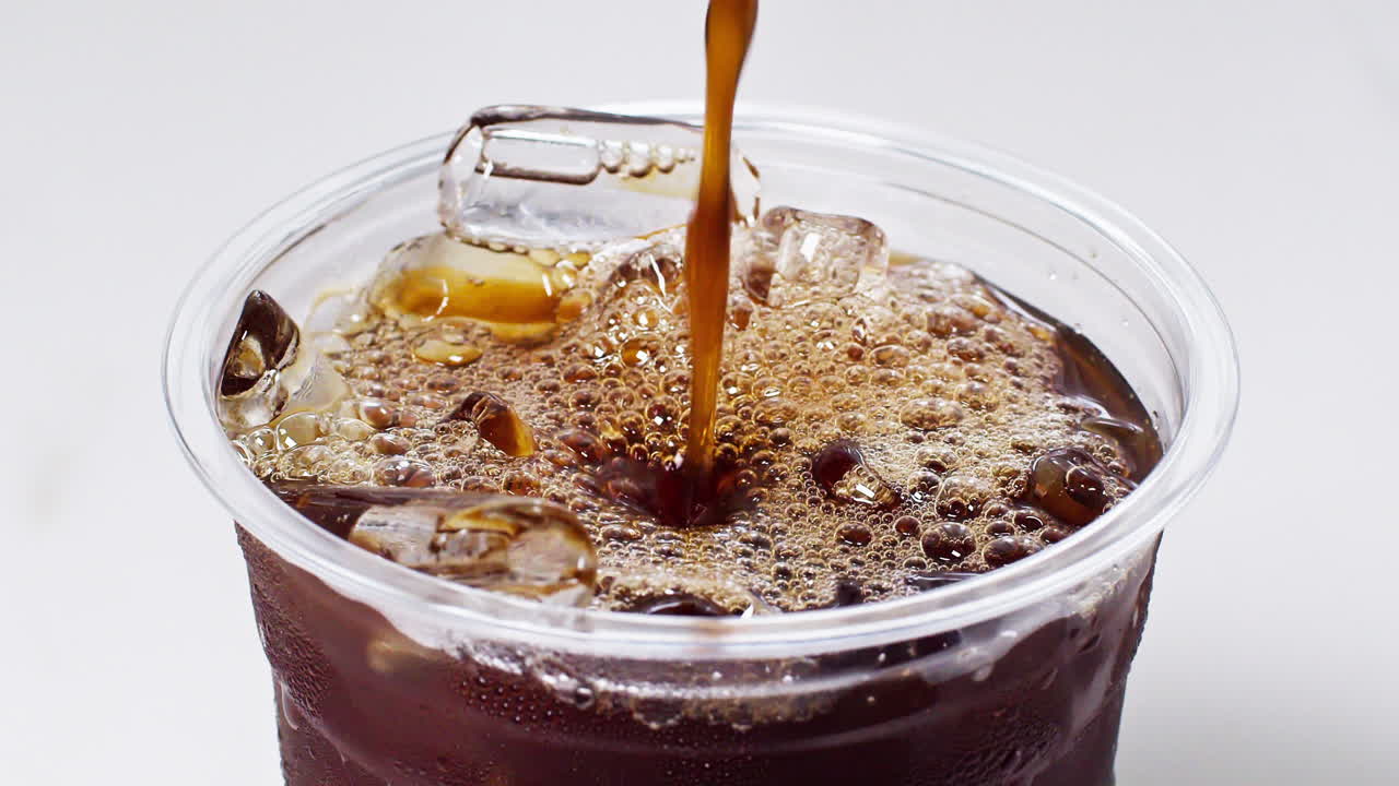 Café Americano helado sobre la mesa. Cámara lenta