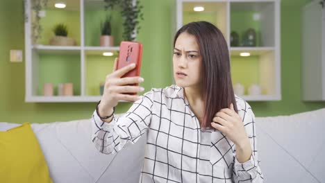 una joven que se da cuenta de que su cabello está roto está molesta.