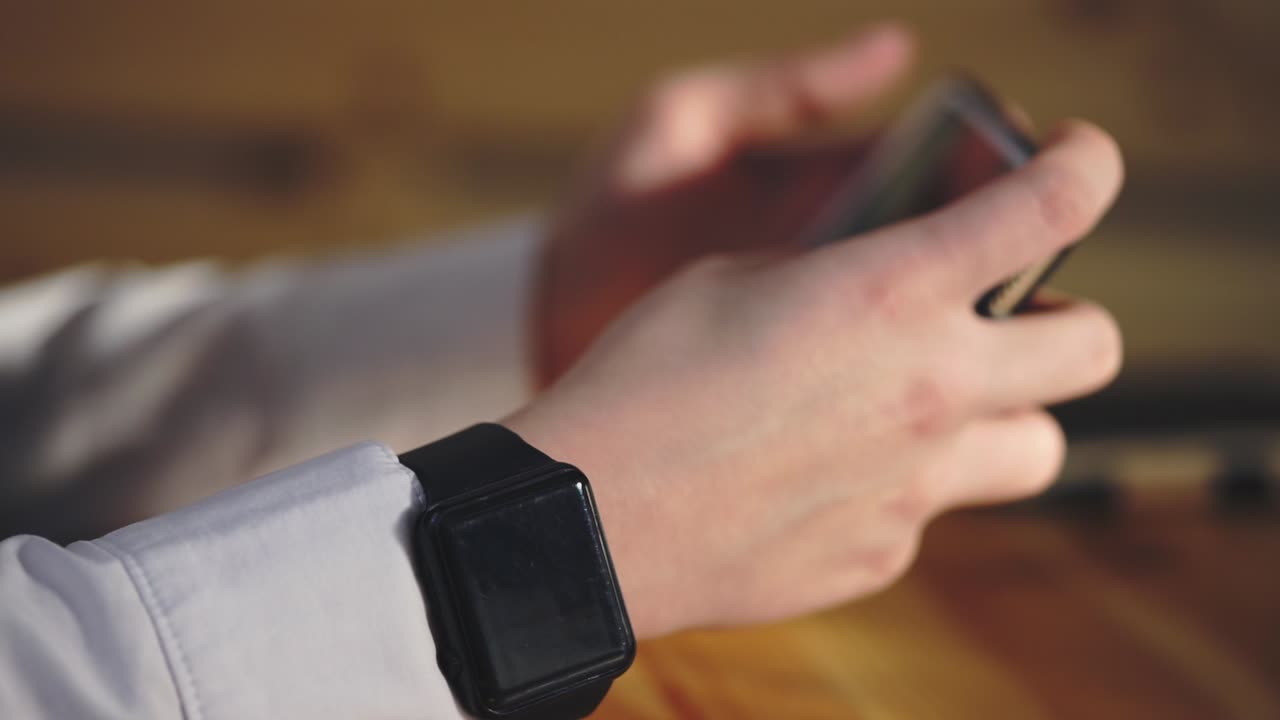 Person using a smartwatch and smartphone