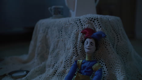 a jester doll on a lace tablecloth