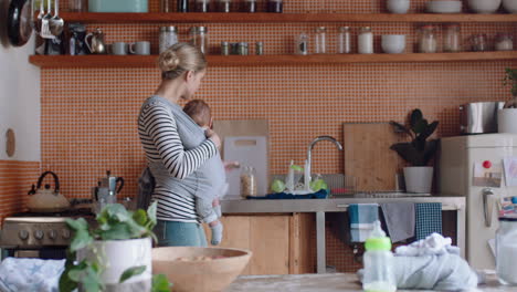 young mother holding sleeping baby at home cleaning kitchen working househould chores mom enjoying motherhood resposibility caring for child