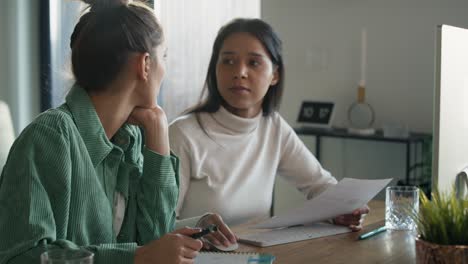 dos mujeres trabajando y analizando algo en la computadora en casa