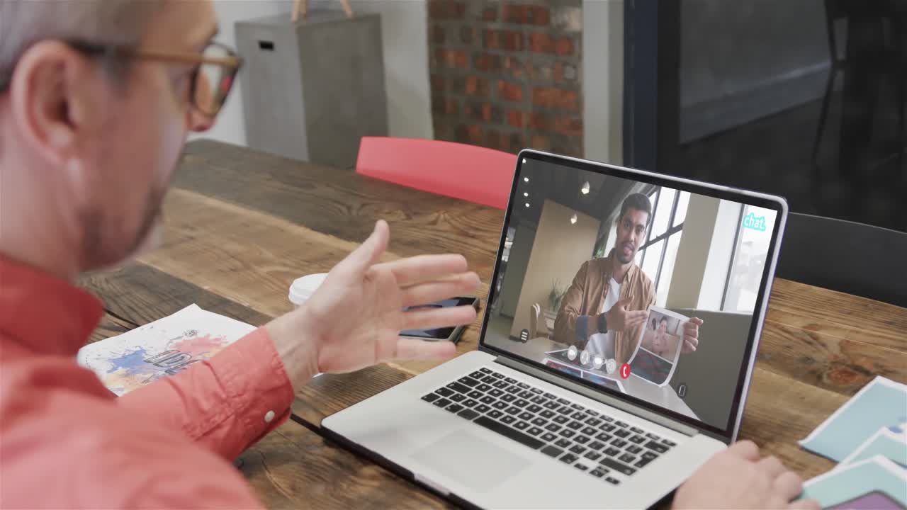 hombre de negocios caucásico en una llamada de video portátil con un colega afroamericano en la pantalla