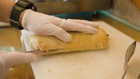 close shot of a man hand cutting white soft sandwich bread at sandwich bistro