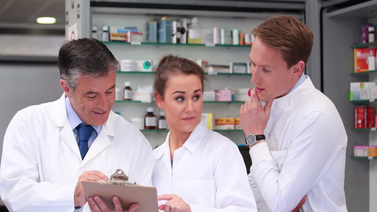 수석 약사가 주니어 직원들과 대화하고 있습니다.