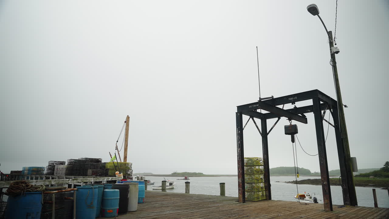 Boat lift lobster traps and fisherman's gear on foggy pier in new England 4k 60p