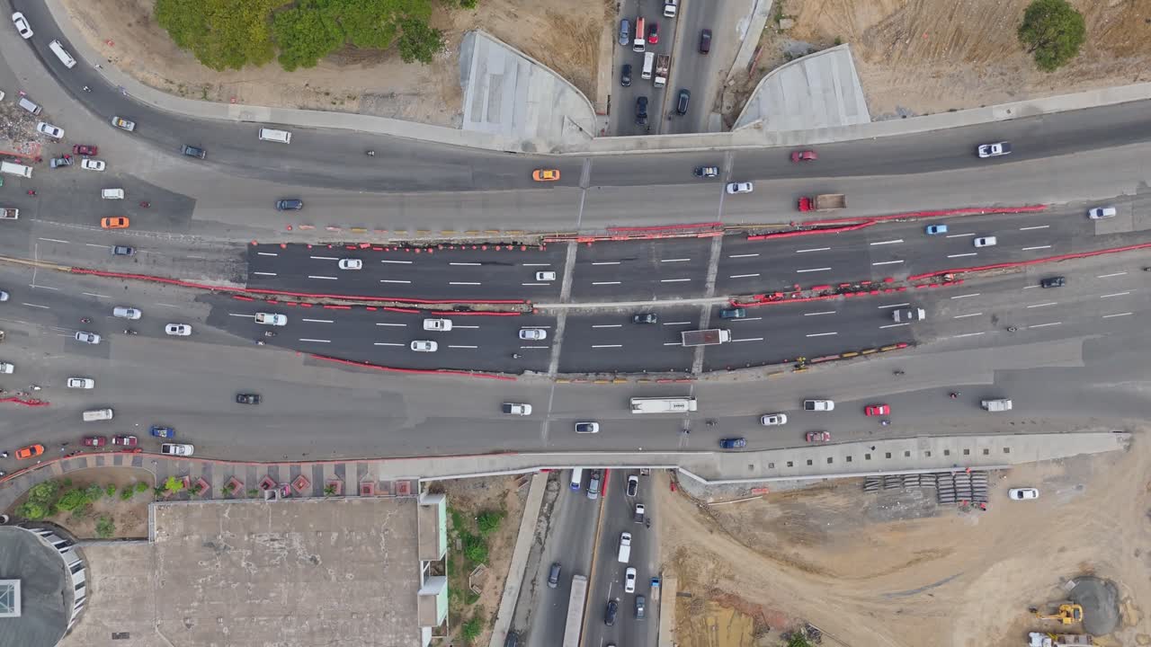 Urban elevated road junction and interchange overpass, construction of Kilometer 9 of Duarte highway, Santo Domingo city in Dominican Republic. Aerial top-down view
