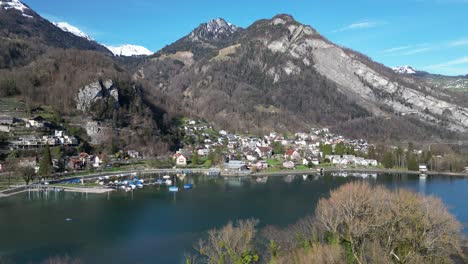clip de avión no tripulado de un pueblo y un puerto junto al lago en los alpes suizos en un brillante día soleado
